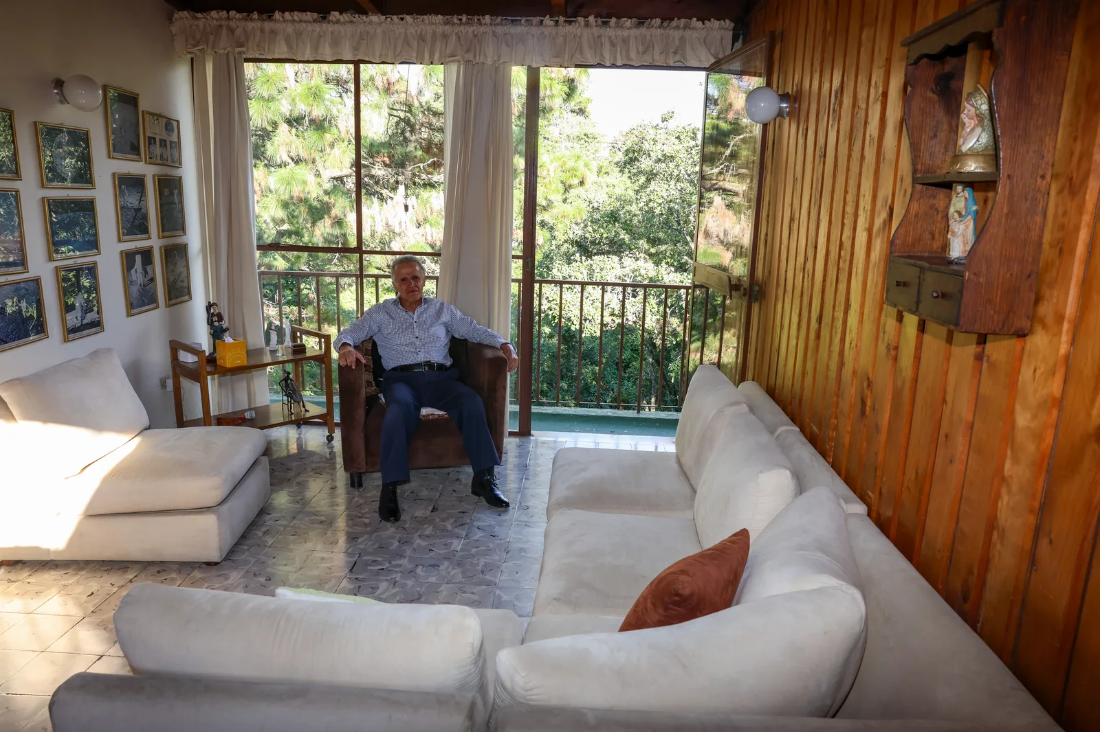 Lic. Fernando Estrada sentado en el consultorio, junto al ventanal con vista al balcón y los árboles